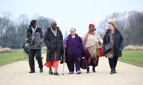 A group of older people walking in a park.