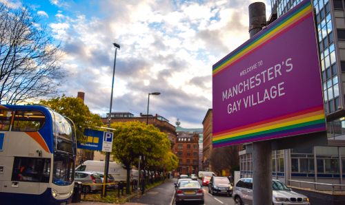 A street with a sign reading 'Manchester Gay Village'.